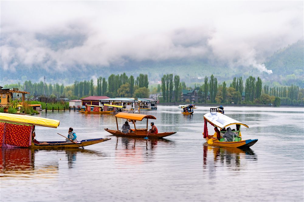 A houseboat on a still lake in Kashmir at golden hour.
